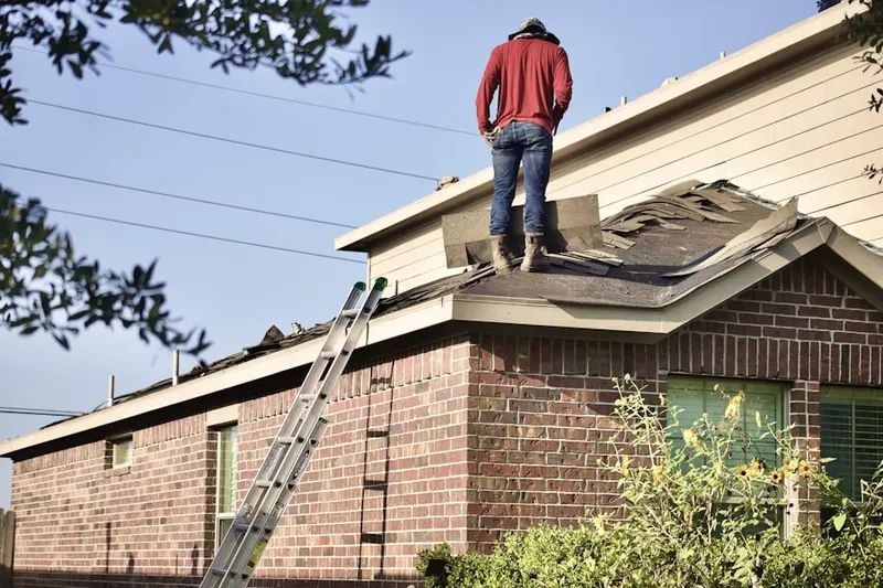 Professional roofer working on a residential roof in Thomaston